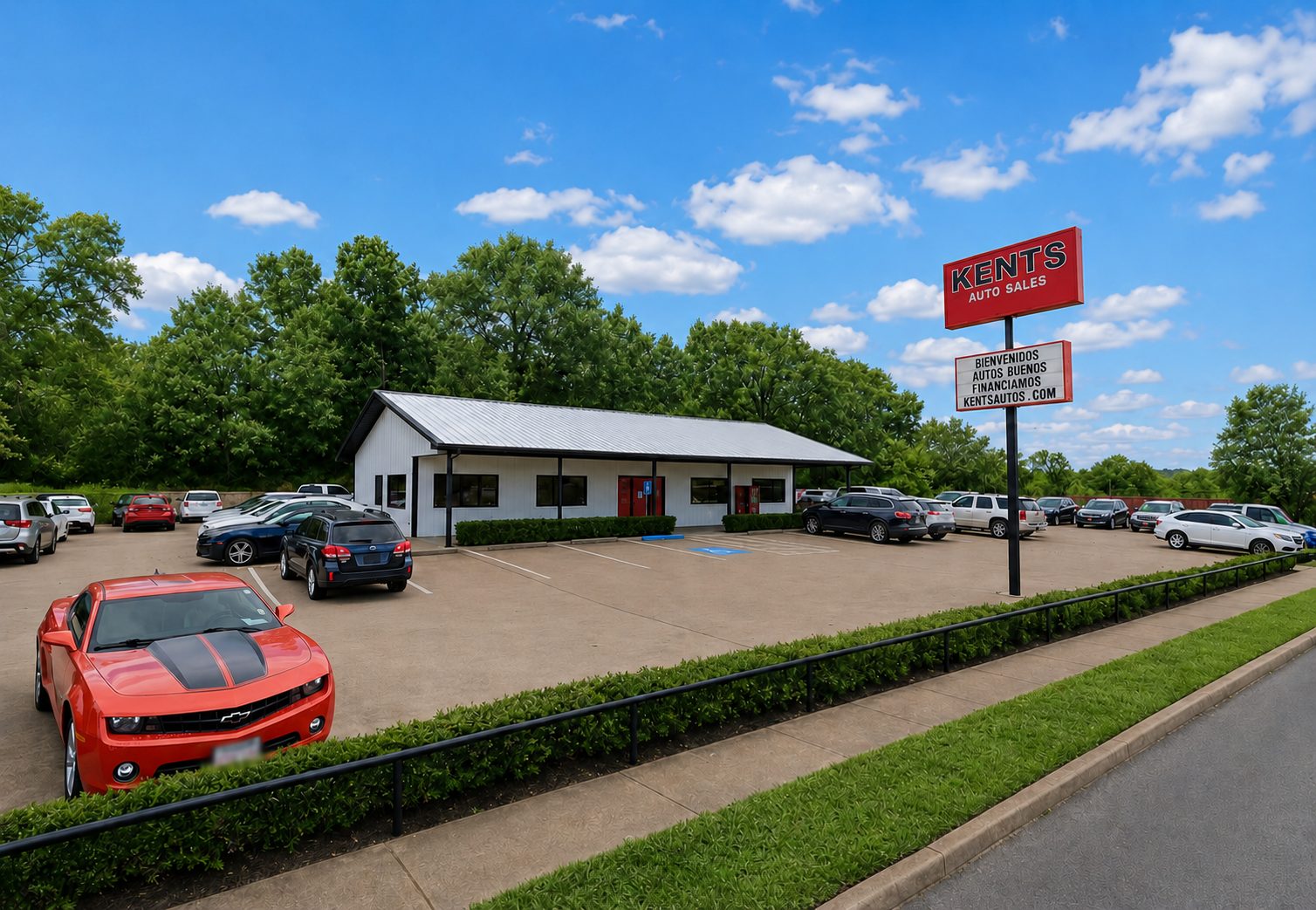 Kent's Auto Sales lot at 409 N. Glenwood Boulevard in Tyler, Texas — white building with red trim, big KENTS sign, red Camaro out front.