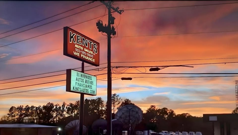 Kent's Auto Sales sign with Spanish-language panel.